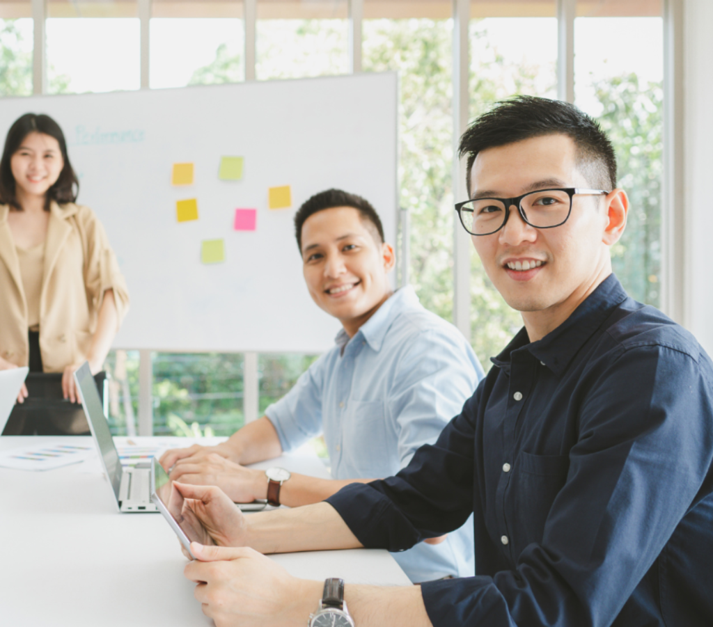 Professional business team working together in modern office with laptops and whiteboard – accounting and compliance services.